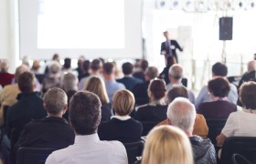 Bijeenkomst event spreker op podium.jpg